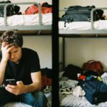 Traveler managing finances on smartphone using budgeting app while traveling abroad